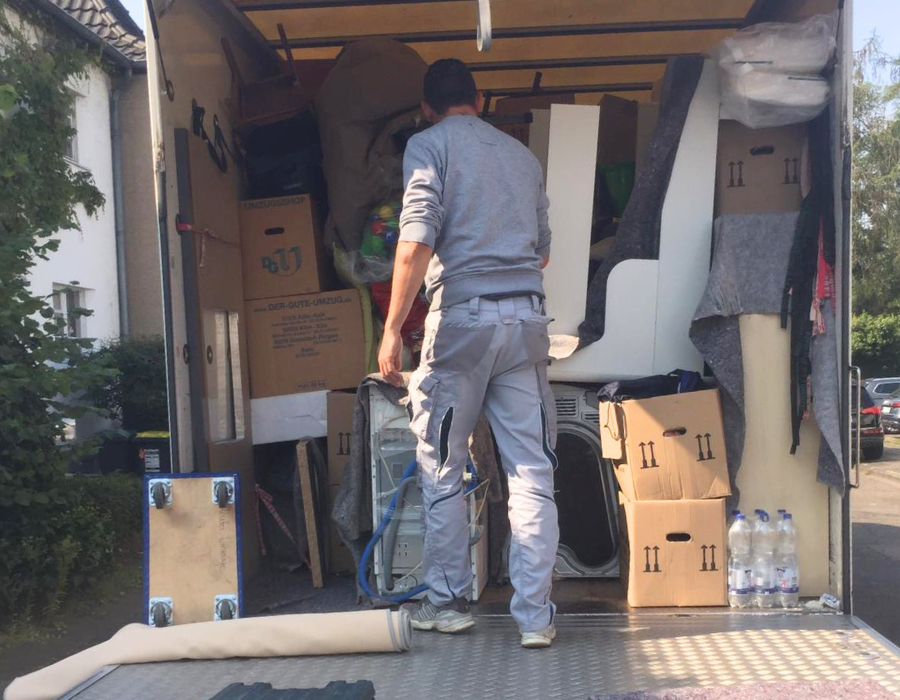 Umzugsunternehmen Köln beim fachgerechten Beladen eines Transporters mit Umzugskartons und Möbeln