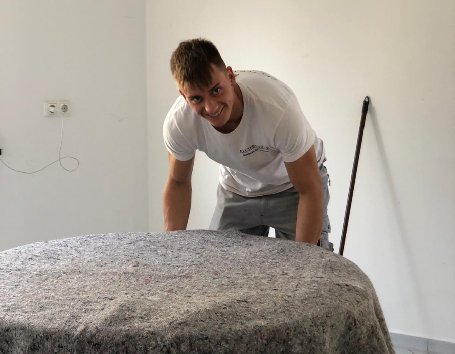 Reuter Umzüge: Umzugsunternehmen Köln beim Schutz von Möbeln mit Decken während eines Umzugs in einer Wohnung.